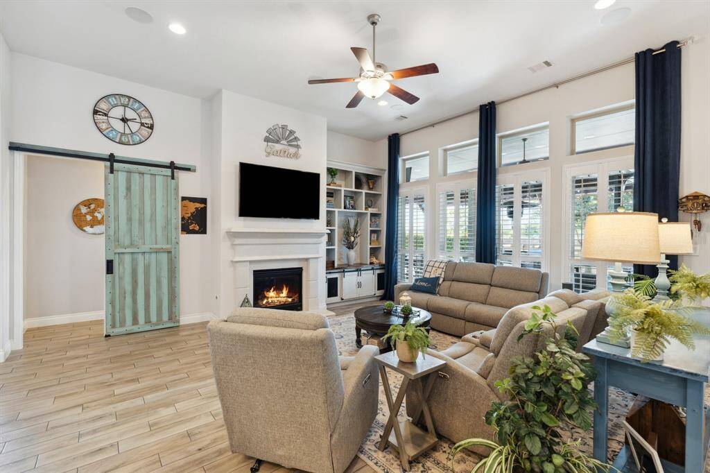 This view highlights the kitchen’s generous counter space and abundant storage. Just beyond, the charming green barn door leads you into the tranquil Primary Suite