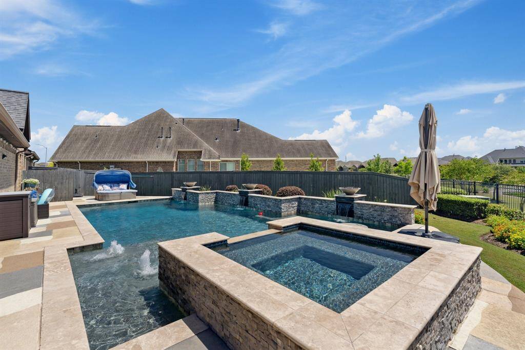 Resort-Style Pool & Spa where you can enjoy your own private oasis featuring a stunning pool with cascading water features, sun shelf, and elevated spa