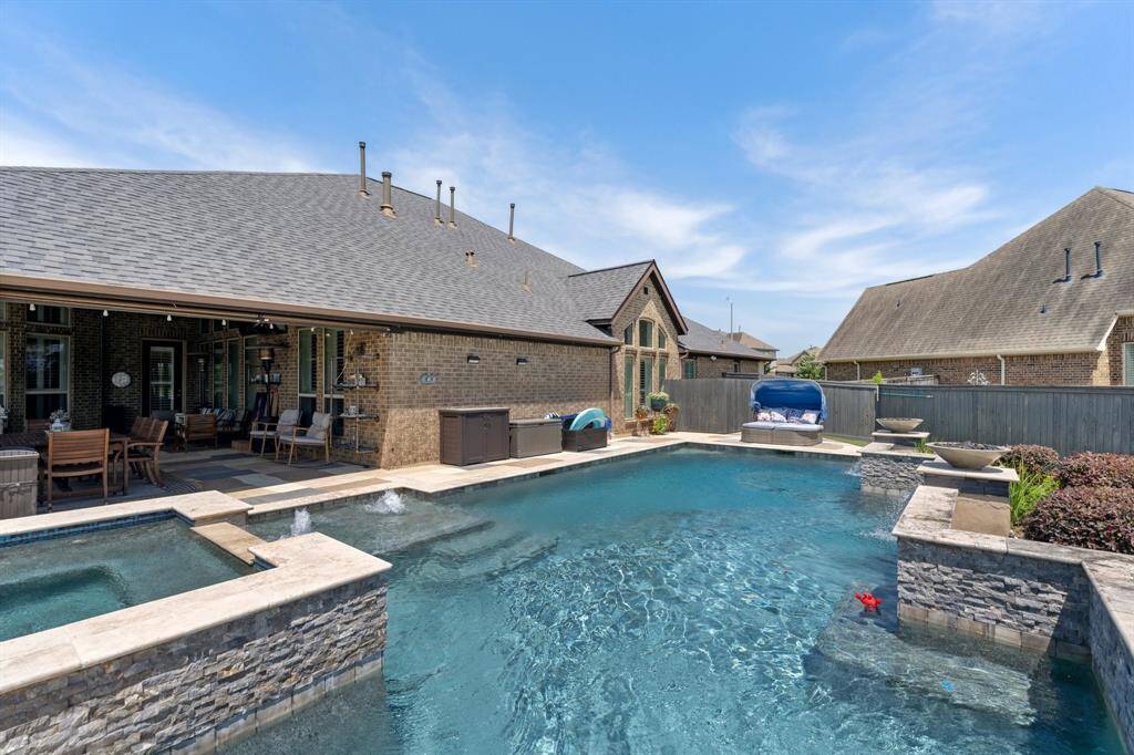 Soak up the sun or retreat to the shade—this heated pool is perfectly positioned next to a covered patio for year-round enjoyment.