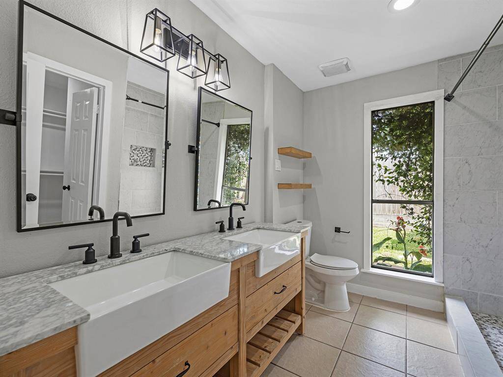 Beautifully remodeled bathroom with double sinks and standing shower
