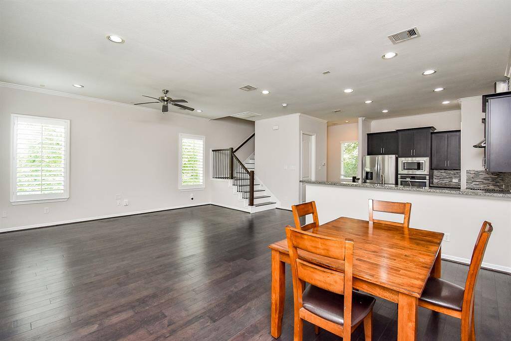 This expansive living space lives large without feeling overdone. Smooth dark floors and oversized windows frame a room that invites both gatherings and quiet mornings.
