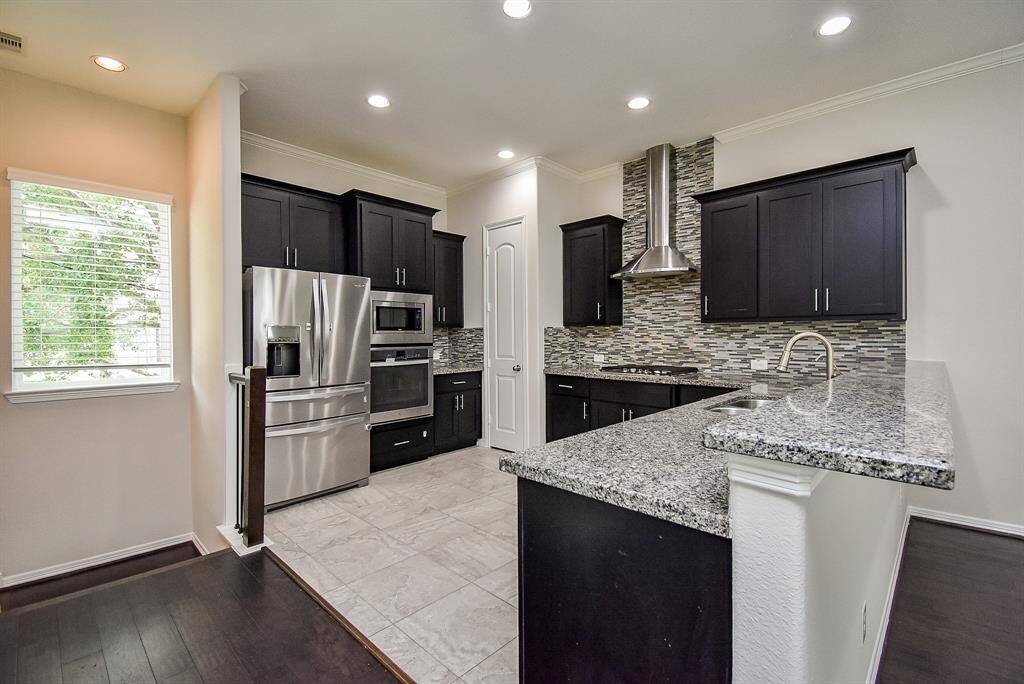 Framed in white trim, the dark, glass-paneled front door sets the tone—contemporary, welcoming, and full of light.