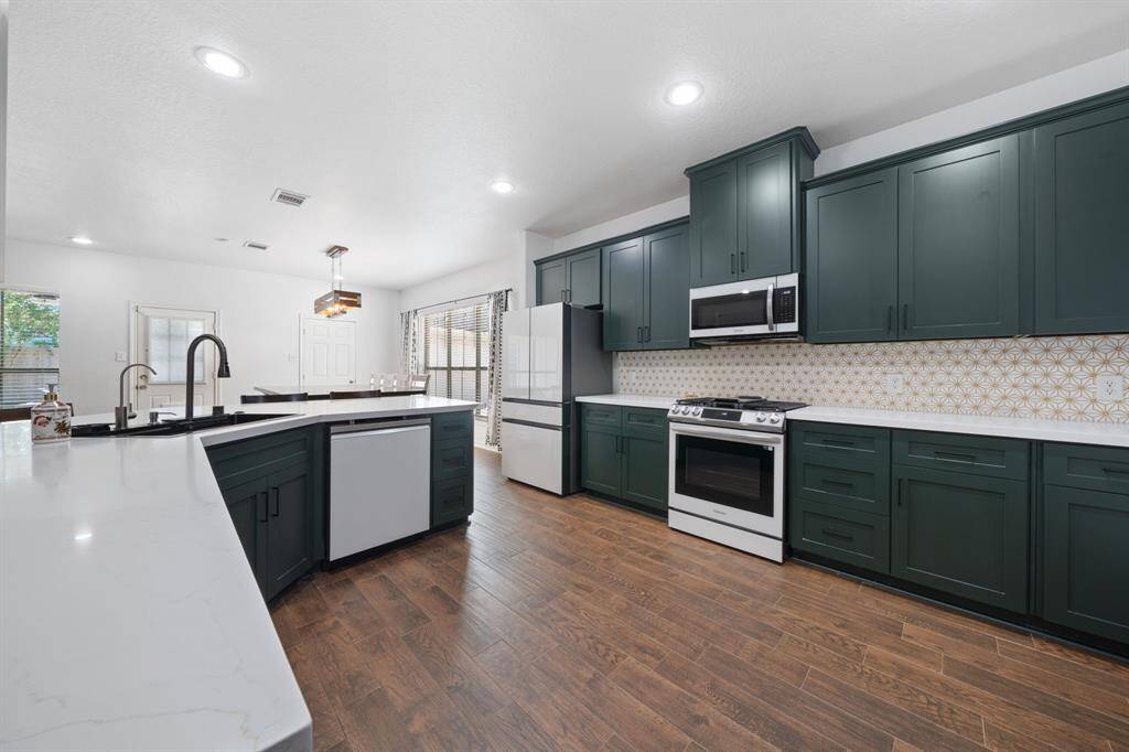 Wonderfully appointed kitchen open to living room, featuring recessed lighting, beautiful cabinetry, granite countertops, and plenty of counter space and room for storage!