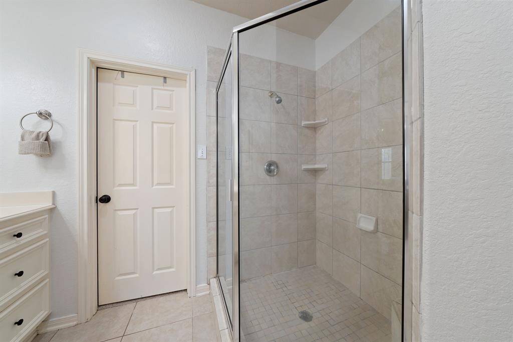 It is complete with a beautiful glass enclosed shower and a tile wall.