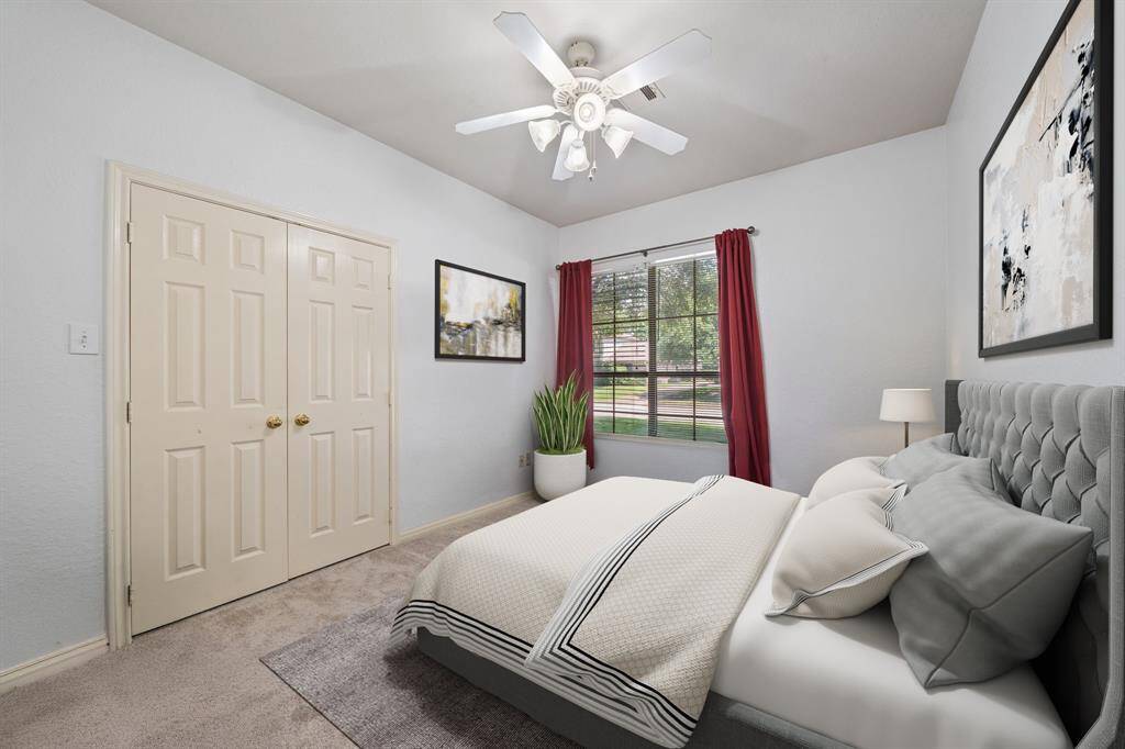 Virtually Staged: Secondary bedroom featuring plush carpet, ceiling fan, large window, and a built-in closet.