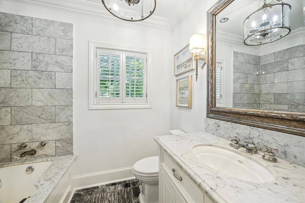 This bath is adjacent to the southwest bedroom and was also renovated with marble counters, chrome plumbing fixtures and a beautiful tub/shower to the left.