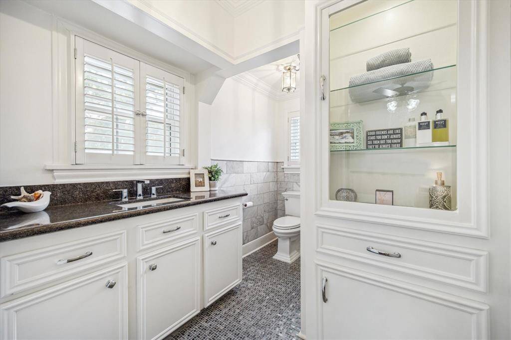 The bathroom was also renovated with custom cabinetry, new plumbing fixtures and a shower enclosure on the other side of the glass front cabinetry.