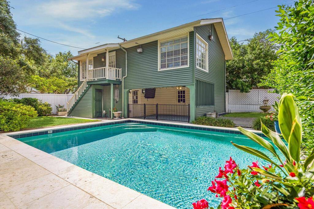 This view is facing northwest and shows the swimming pool, the covered patio and the stairs that lead to the guest suite.