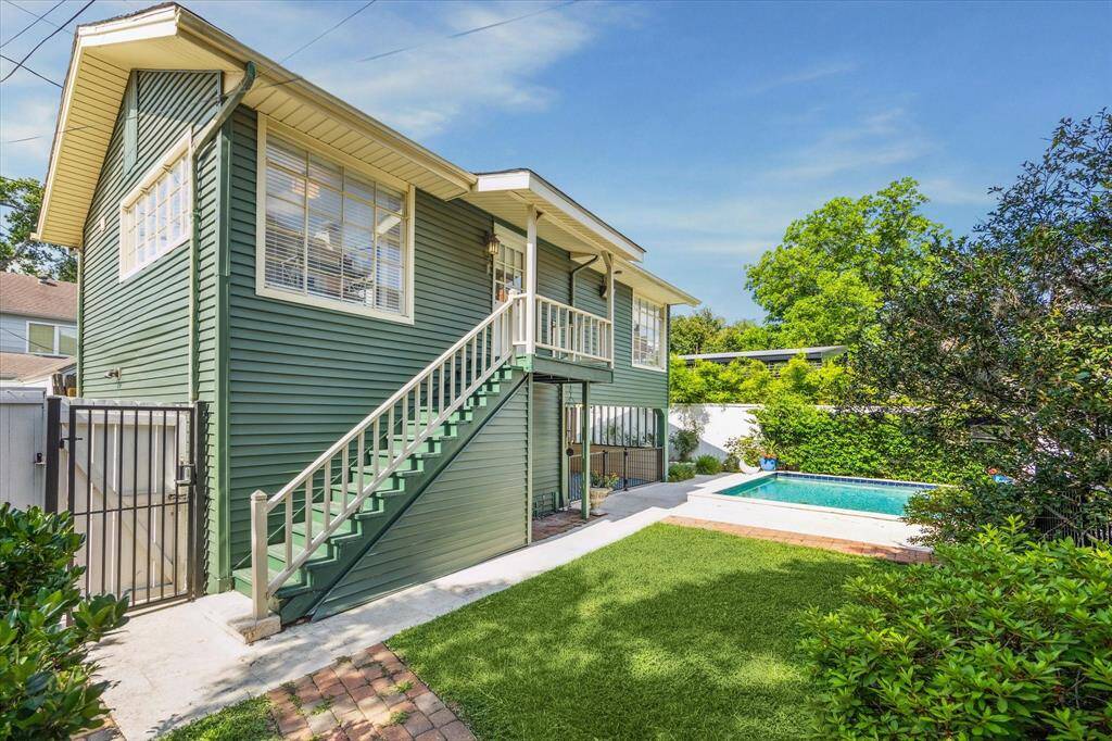 The stairs to the guest suite are adjacent to a wrought iron gate that leads to the driveway.