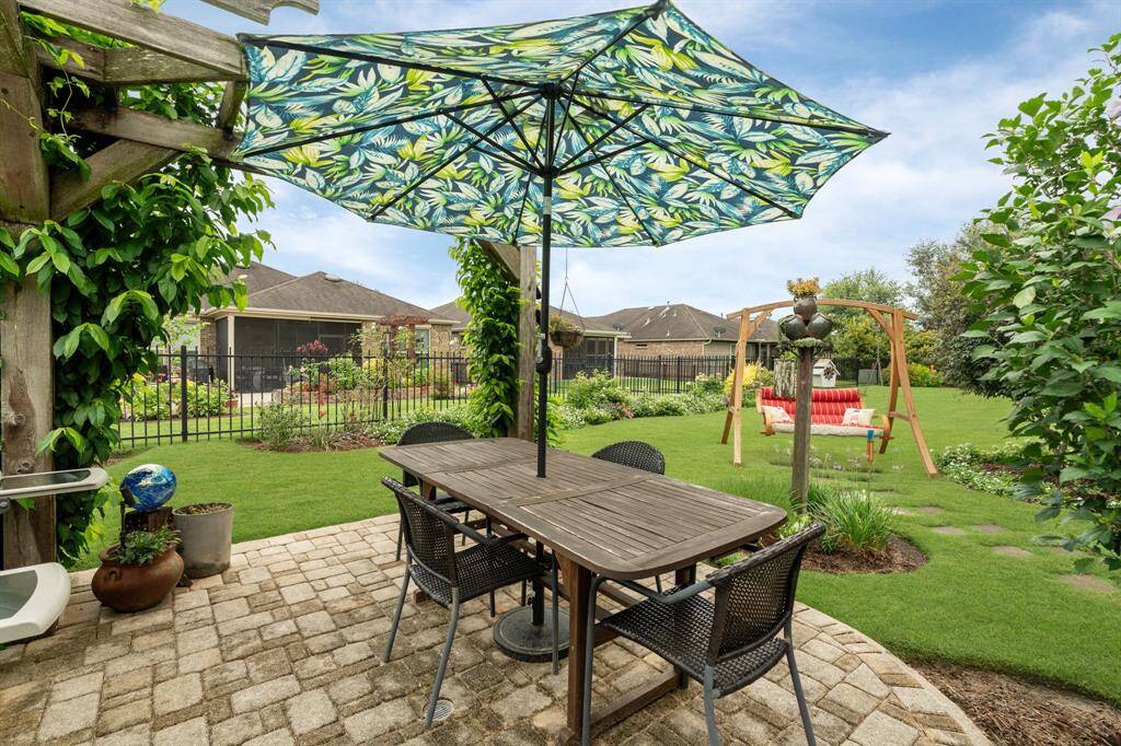 What a beautiful setting to enjoy a steak dinner and a glass of wine outdoors, surrounded by lush, mature landscaping.