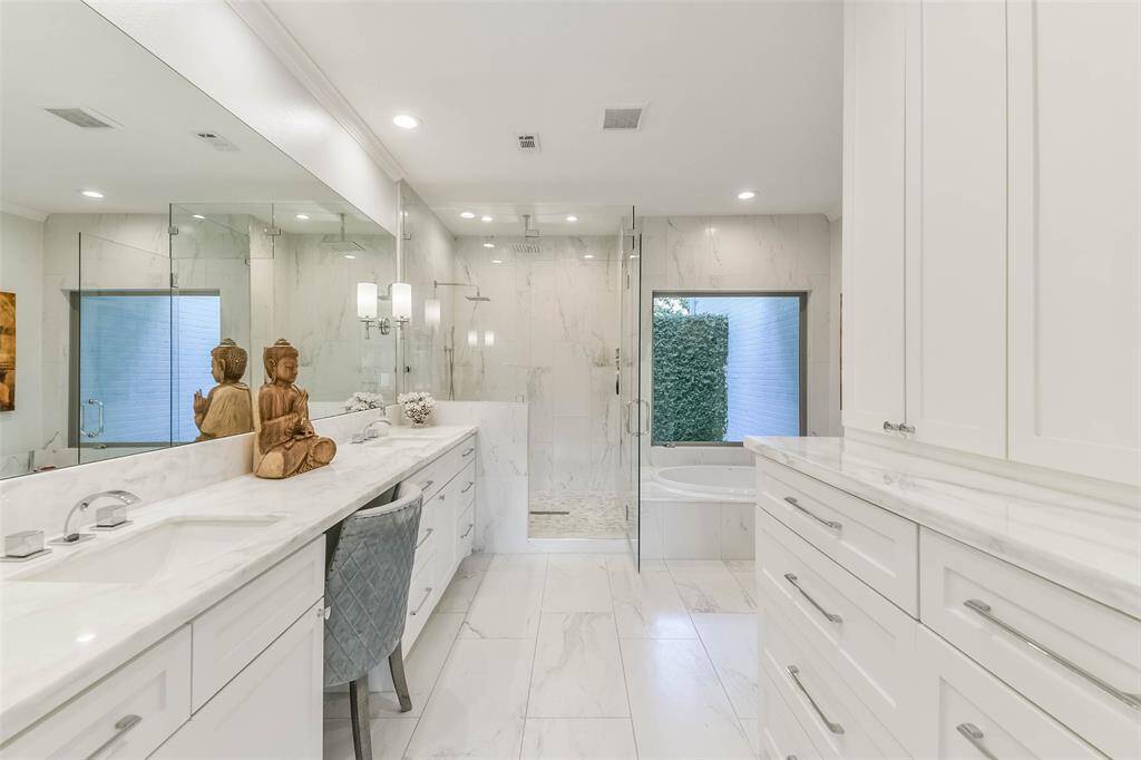 Primary bath offers double sinks and a built in dresser outside of the walk in closet.