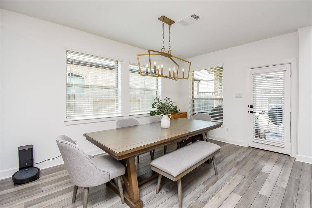 Just off the kitchen, the dining area is generously sized with a contemporary chandelier and access to the patio through a glass-paneled door—ideal for indoor-outdoor entertaining.
