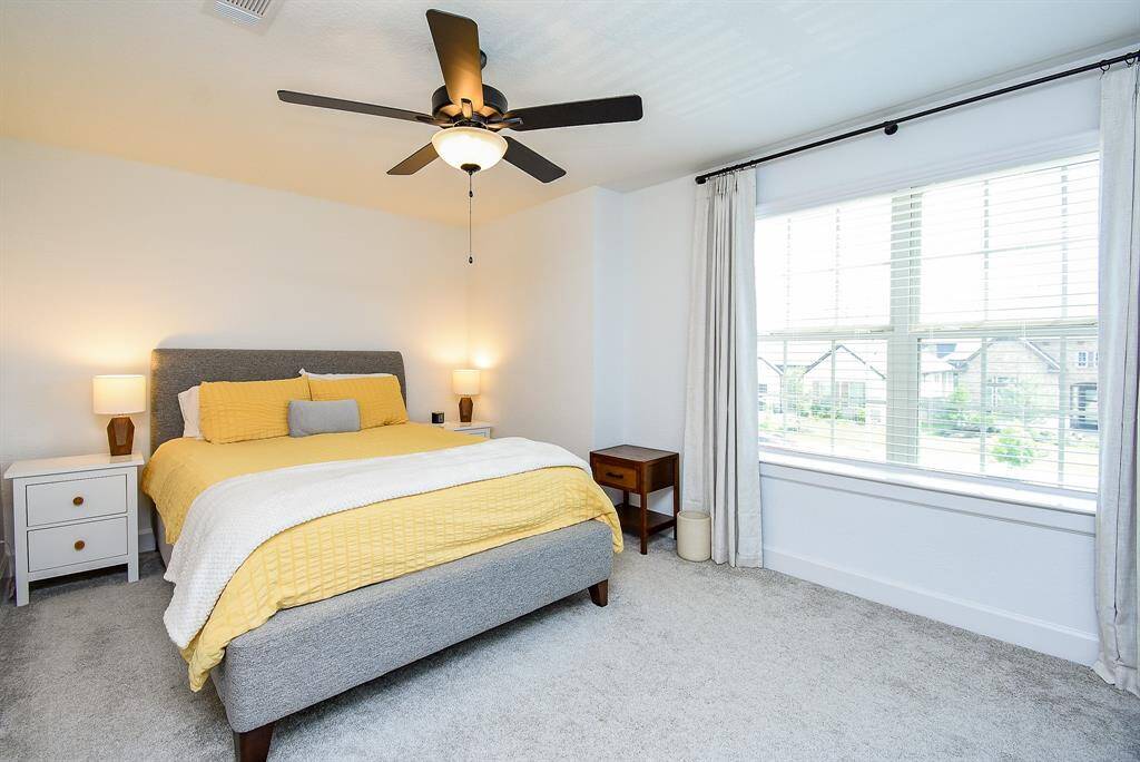 This bright bedroom offers both privacy and functionality, with a private full bath just steps away. A large window and ceiling fan complete the space.
