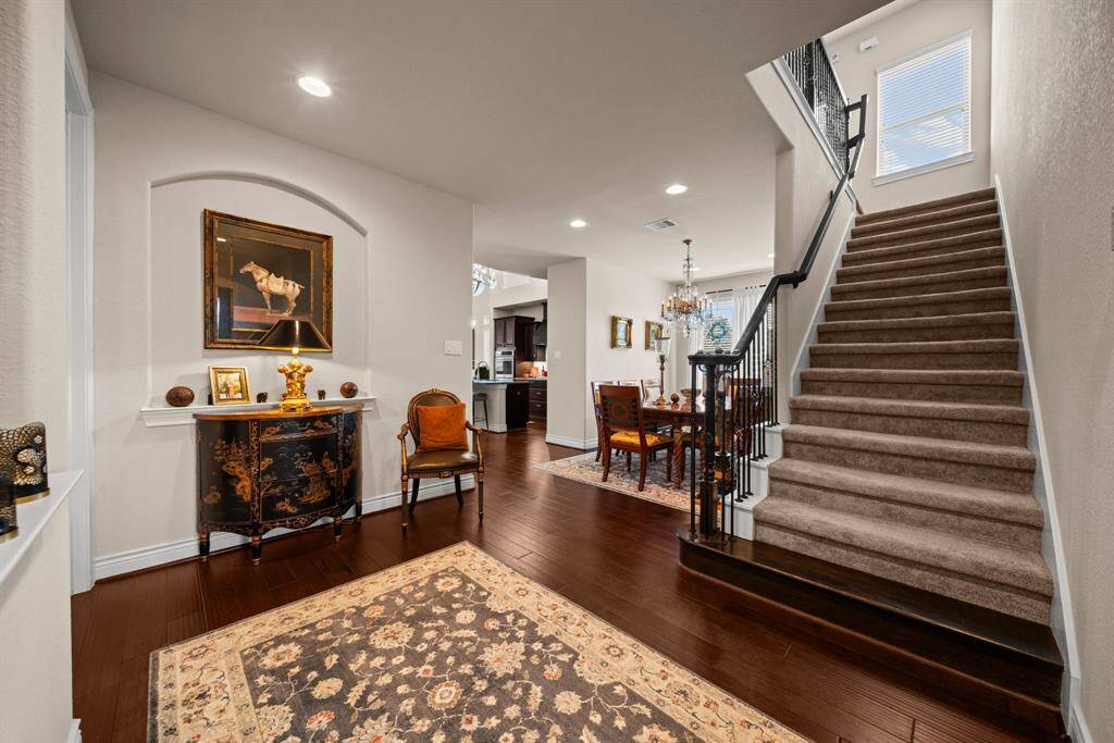 The gorgeous entry welcomes you with rich engineered wood flooring and many upgrades