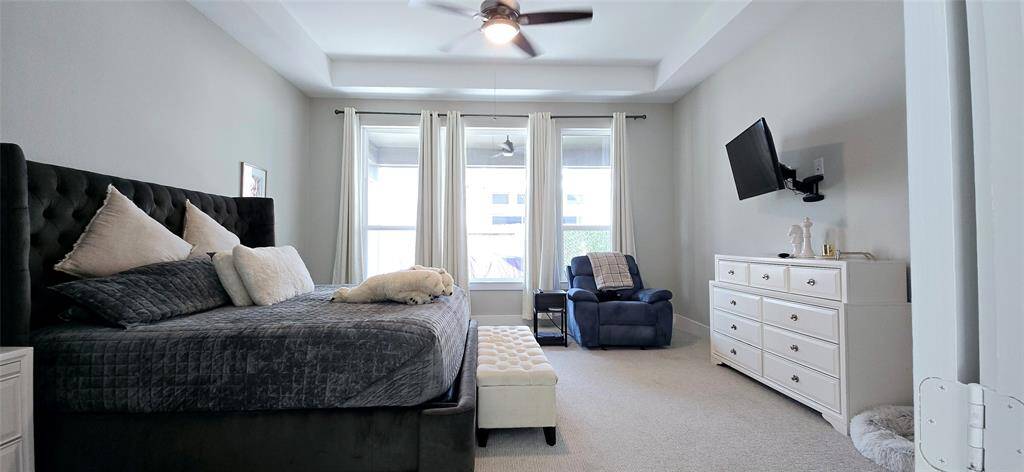 Serene primary bedroom designed for comfort and relaxation, luxury carpeting with a ceiling fan.