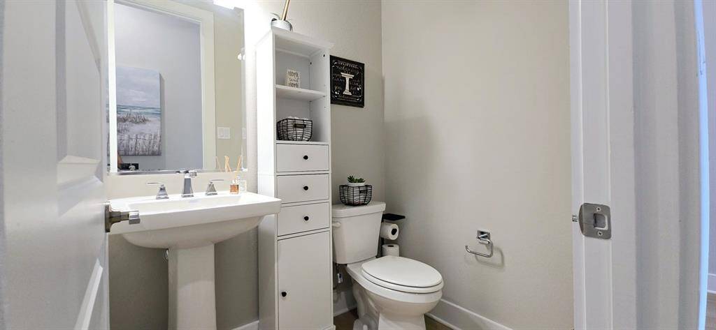 half bath for guests convenience, decorative mirror above the vanity.