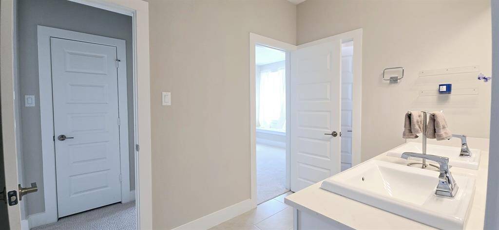 A functional and stylish Jack and Jill bathroom designed to share use between two bedrooms. the layout includes two sinks equipped with a large mirror, storage below and modern features. bathtub and shower combo, offering separate access points from each bedroom.