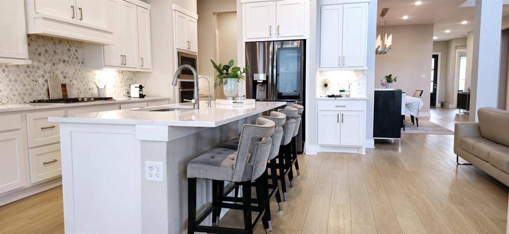 Modern and functional kitchen with an open layout, white cabinetry with ample storage complimented by high quality countertops. Stainless steel appliances.