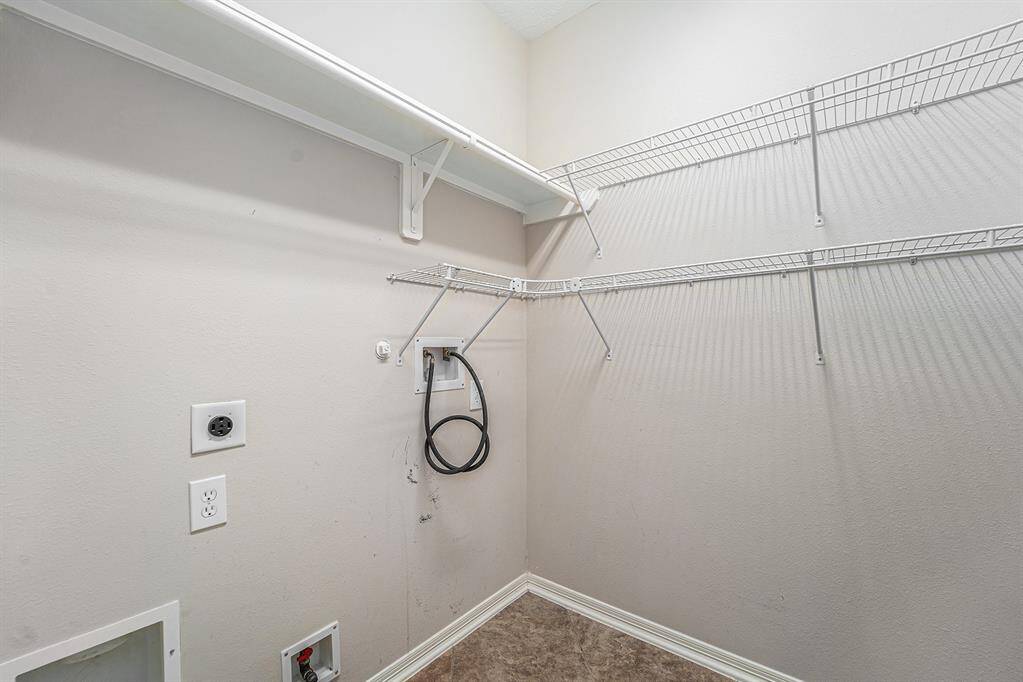 A spacious utility room offers plenty of shelving space for storage!
