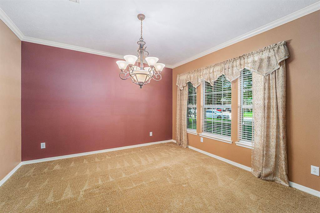 A formal dining room is anchored by a wonderful chandelier!  Imagine spending holidays sharing a meal, or late-night evenings playing cards with the neighbors!  This could easily convert into a large home office once you see the large casual dining space in the kitchen!