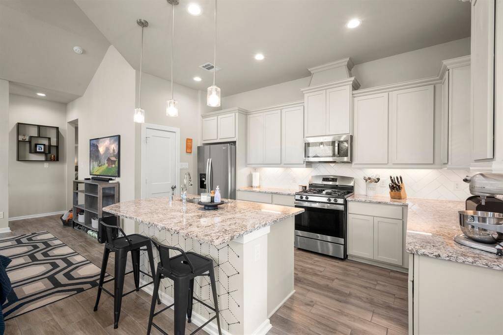 Kitchen with stainless appliances including gas range.