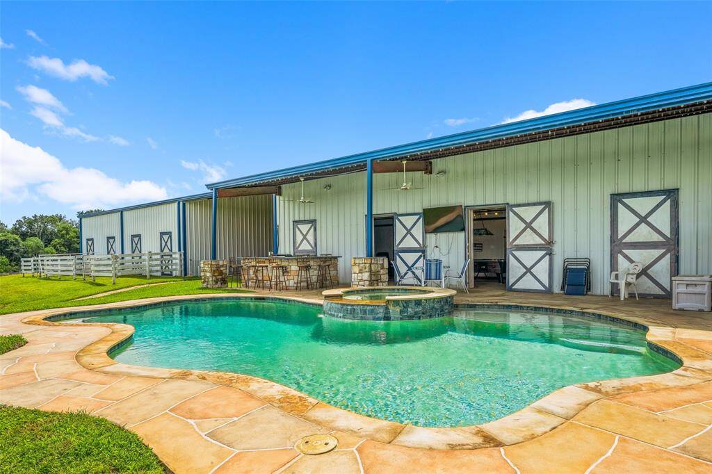 Entertain your guests in this Backyard Oasis complete with pool, hot tub, TV, and outdoor kitchen