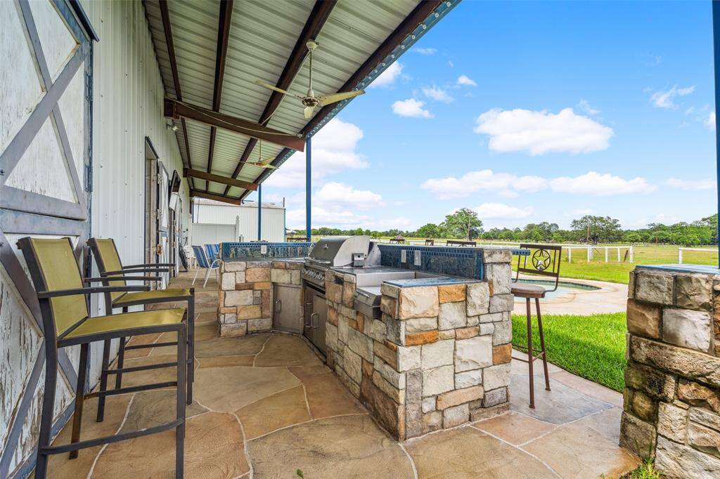 Outdoor kitchen complete with BBQ pit, sink and burner stove.