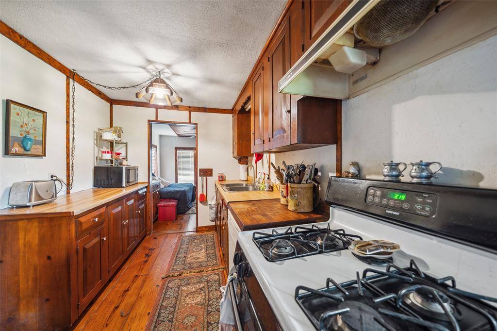 Guest house kitchen showing beautiful cabinetry and wood floors.