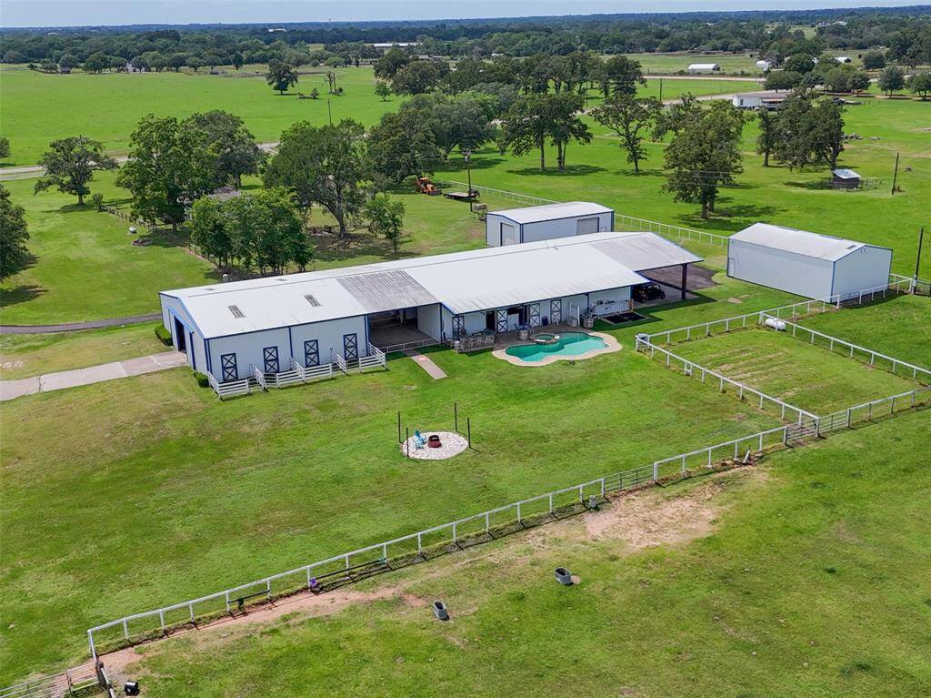 View of Barndo showing pool patio and horse stall turn out paddocks.