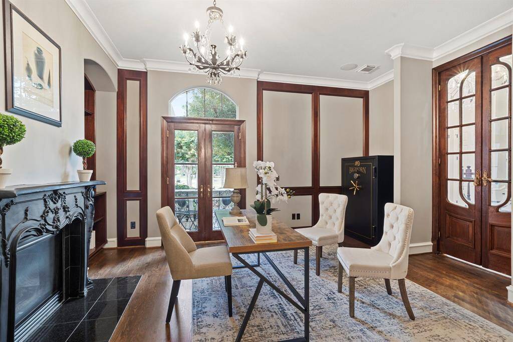 The home office has custom wall molding, rich millwork, gas fireplace, Big Horn gun safe, and built-ins with adjustable shelving.