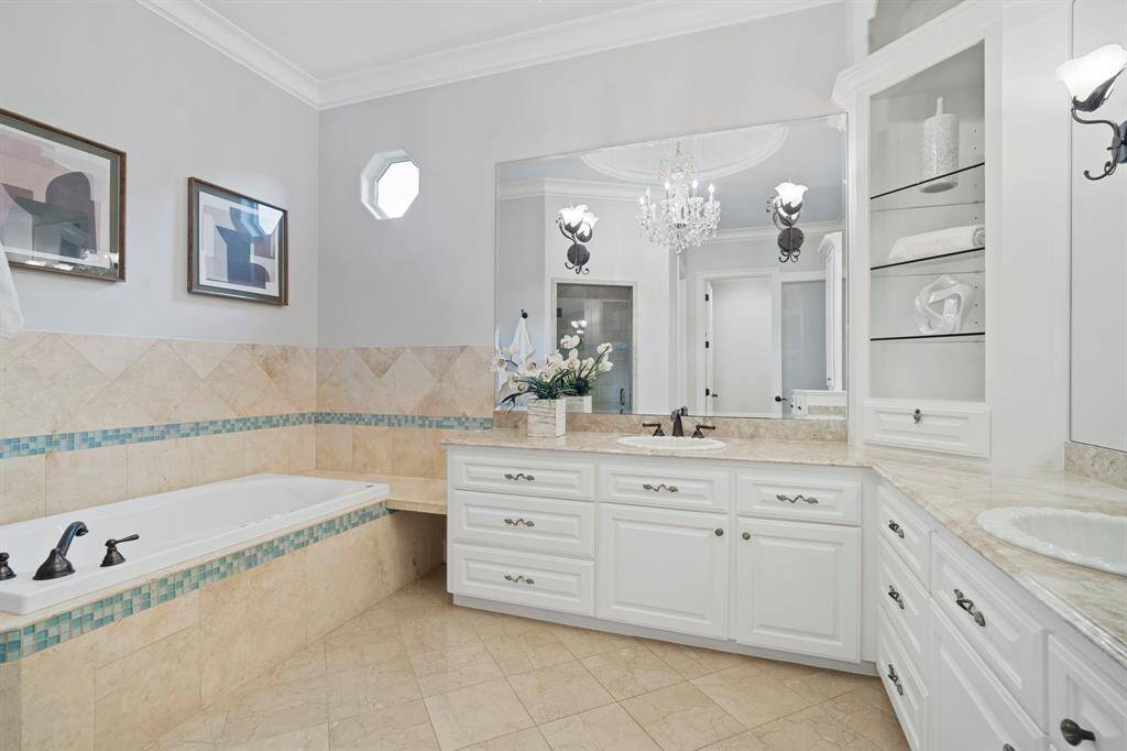 The primary bathroom features tile floors, dual sinks, and a separate tub with tile surround.