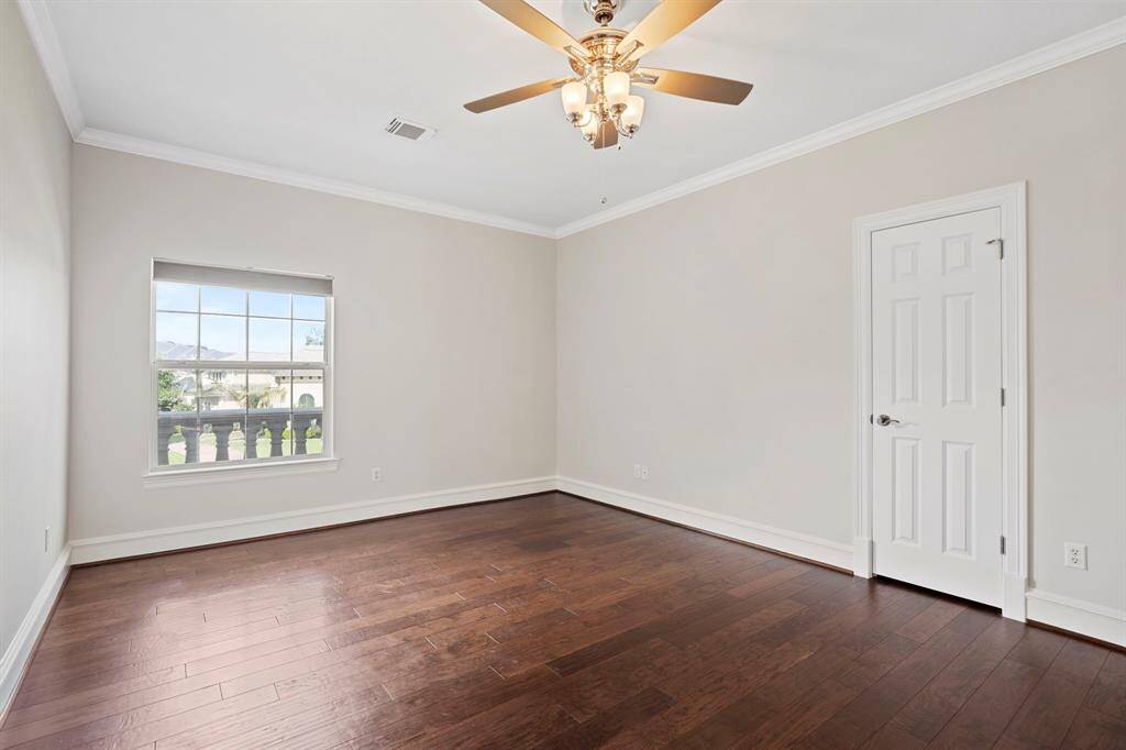 Third bedroom features a largewindow, ceiling fan, and beautiful flooring.