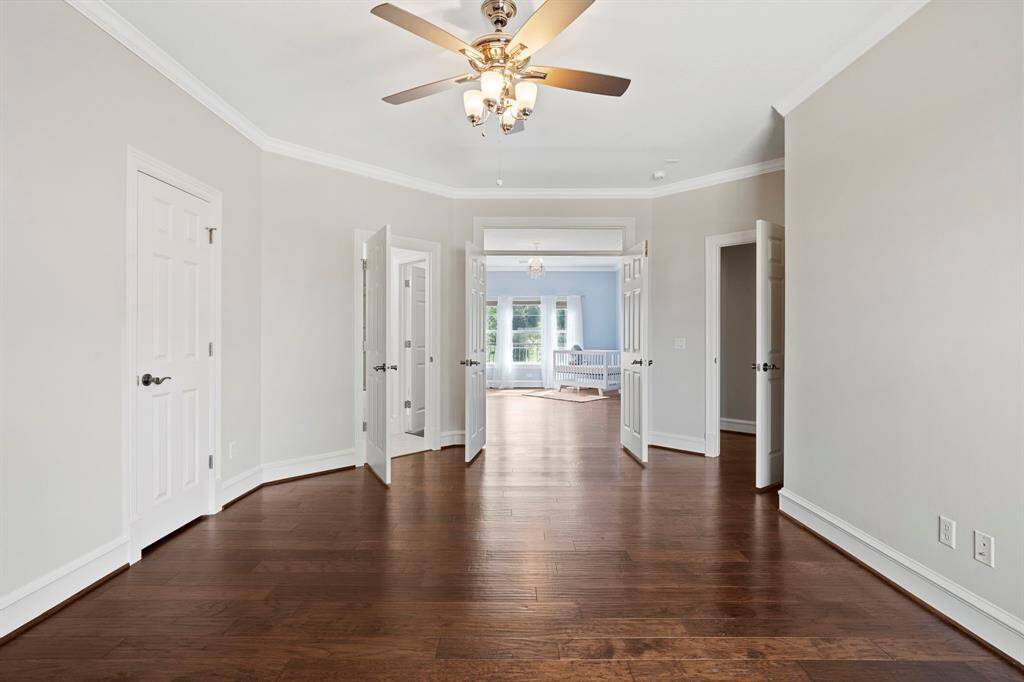 Third bedroom features a largewindow, ceiling fan, and beautiful flooring.