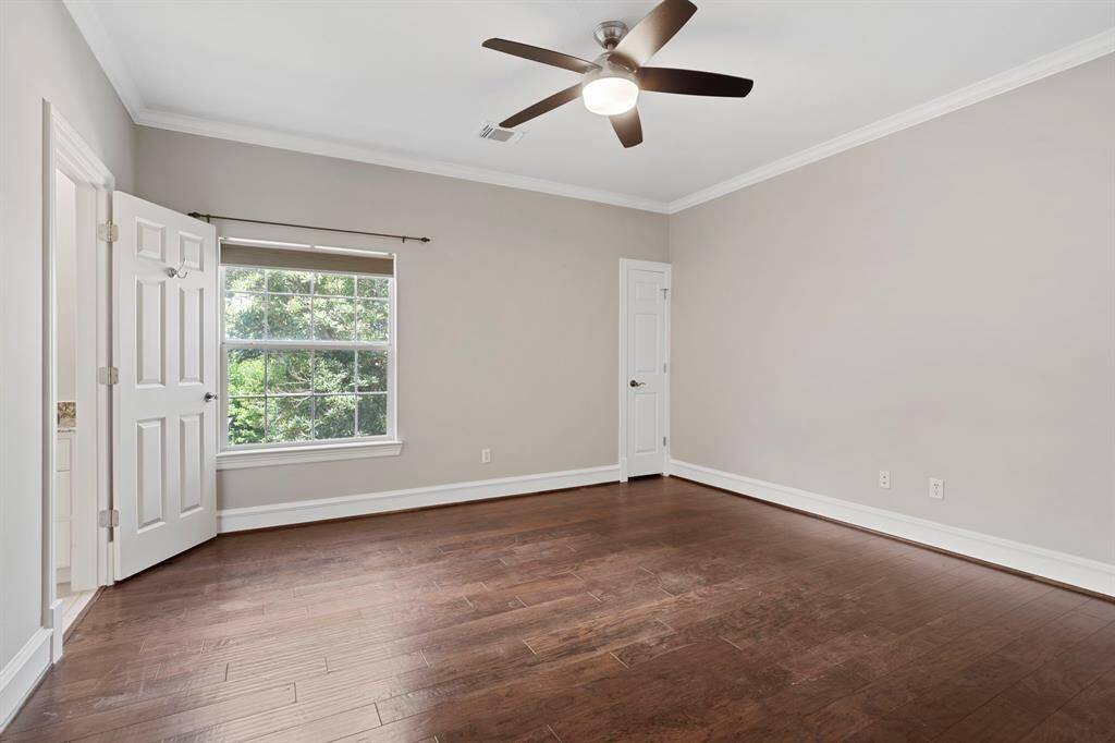 Fourth bedroom features a largewindow, ceiling fan, and beautiful flooring.