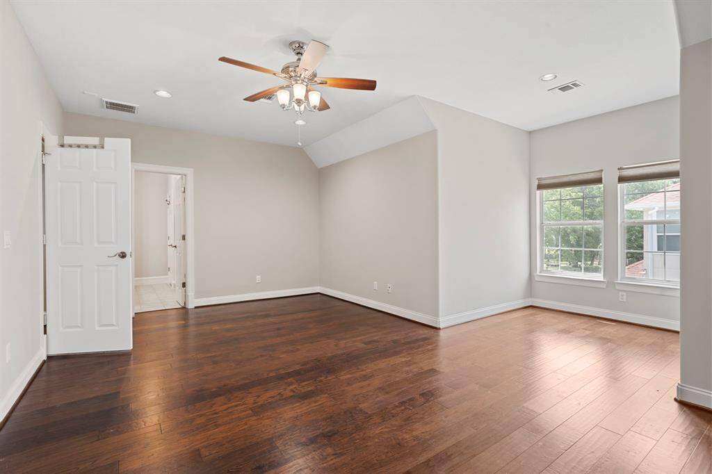 Fifth bedroom features largewindows, recessed lighting, and beautiful flooring.