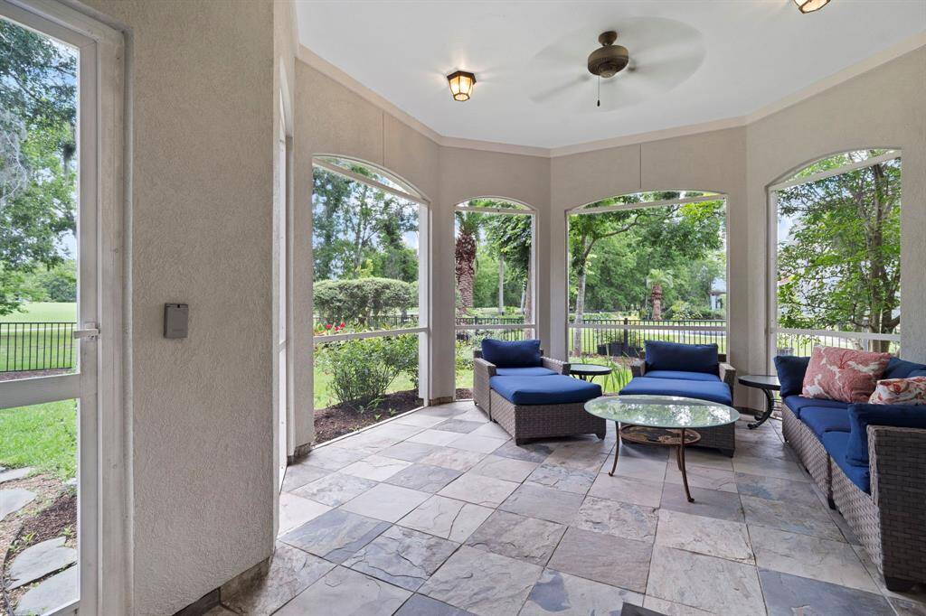The sun room features tile flooring, ceiling fan, and plenty of space for a sitting area!