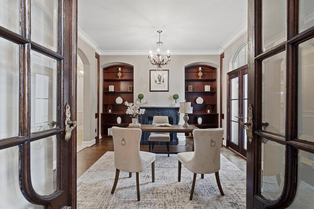 Behind the French-inspired hand carved double doors is the private home office.