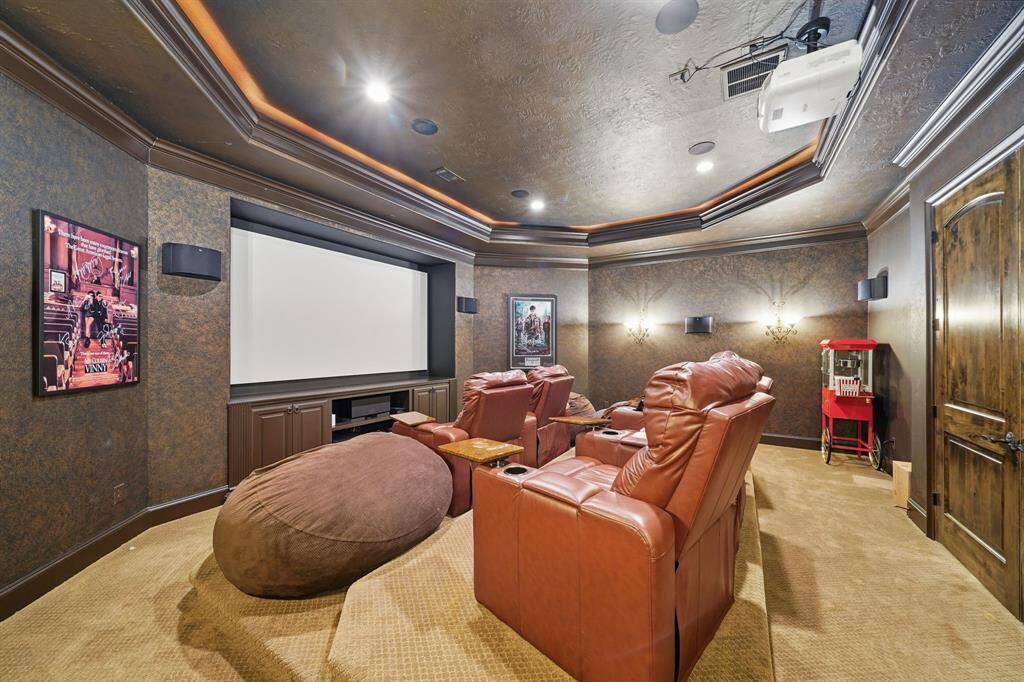 The media room features plush carpet, custom lighting, and projector space.