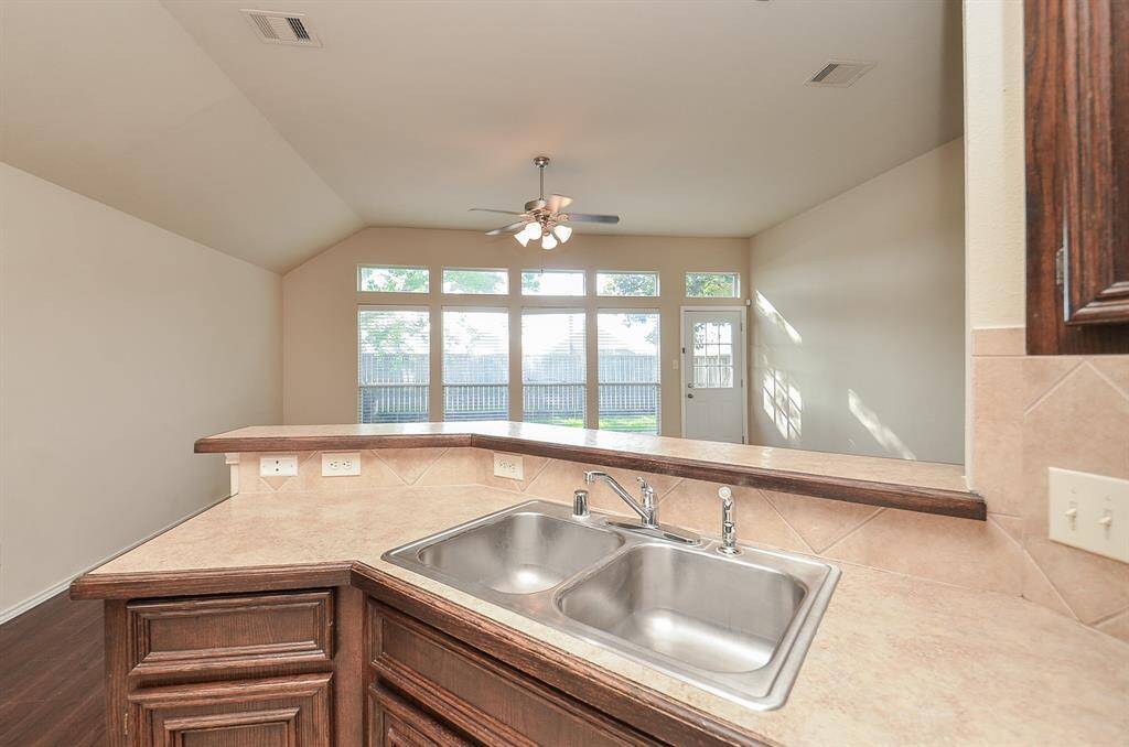 The kitchen features a dual sink set in beautiful countertops, positioned to offer a clear view of the backyard.