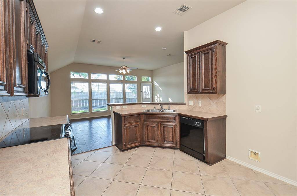 This kitchen is equipped with stainless steel appliances, paired with a custom basksplash and a gorgeous countertops.