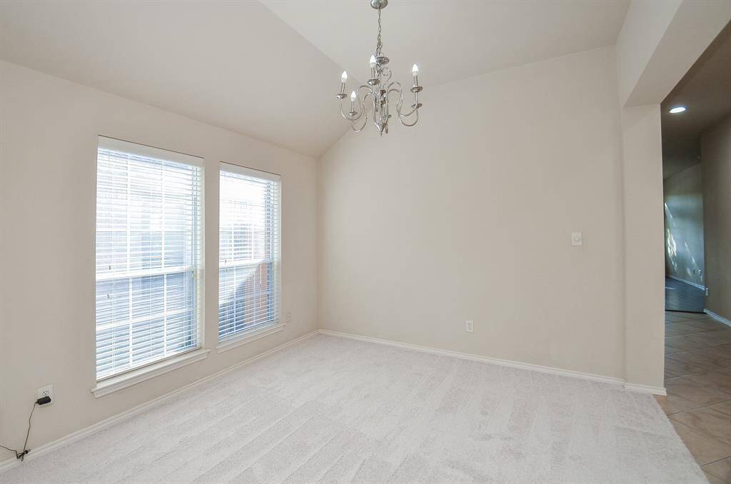 The formal dining room with art niche flows into a large living area featuring a wall of windows for natural light.