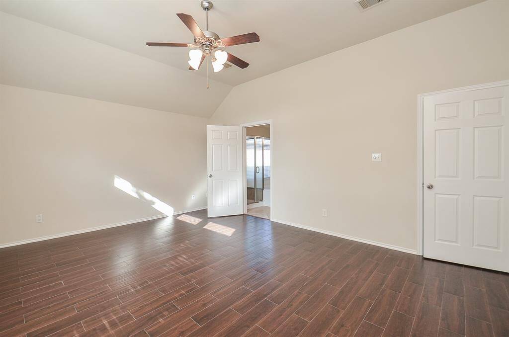 Primary bedroom featuring a high ceiling and a spacious ensuite bathroom for added comfort and privacy.