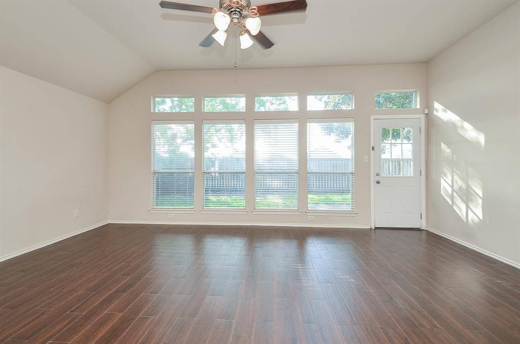 Four large windows flood the room with natural light and offer direct views of the lush backyard.