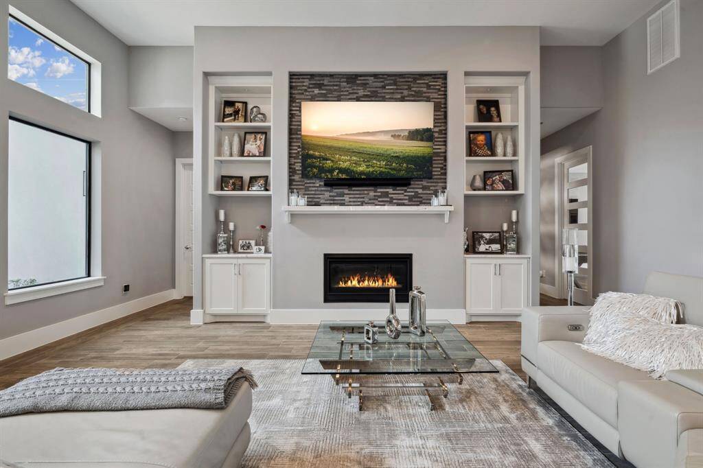 The spacious living room is enhanced by a cozy fireplace and elegant built-ins flanking the accent wall, creating a warm and inviting atmosphere. Relax and entertain in this inviting living room, the perfect space to gather with friends and family.