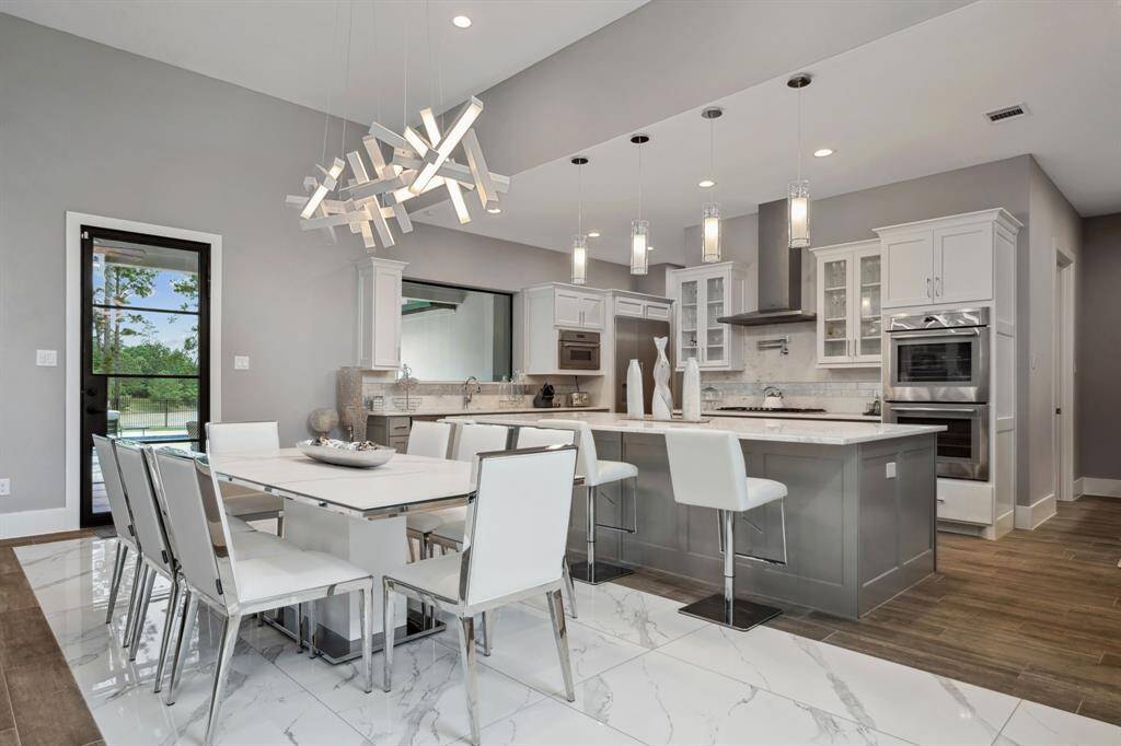 The dining room seamlessly flows into the kitchen, creating an open and spacious feel, enhanced by soaring ceilings throughout.