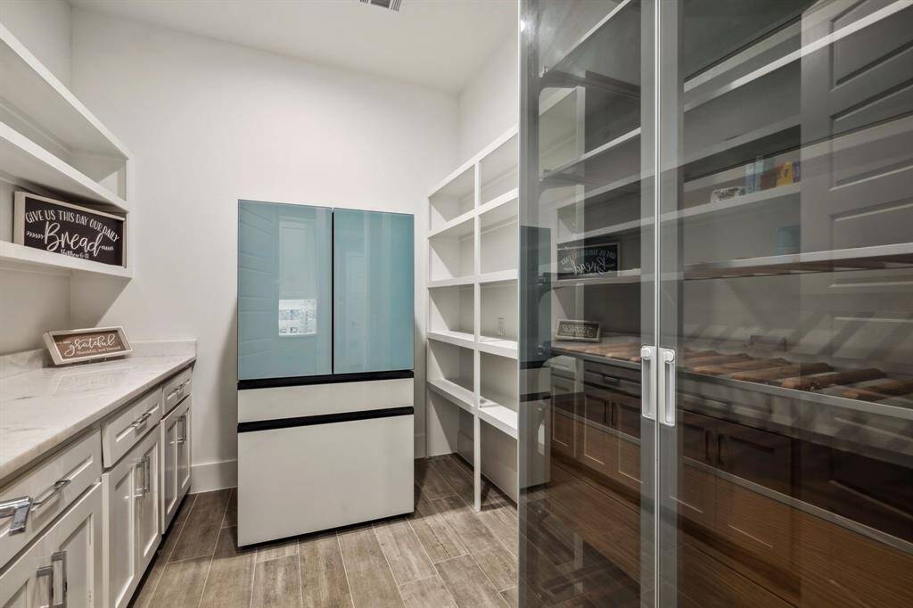 The kitchen boasts a spacious butler’s pantry and abundant storage, offering both functionality and elegance.