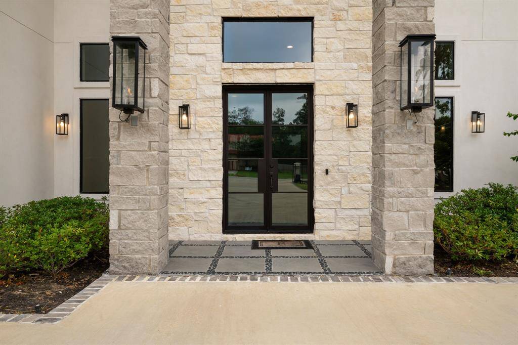This impressive entrance showcases a striking blend of stone accents and soaring rooflines, designed to create a warm and inviting welcome.