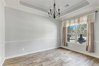 Formal dining room with so much natural light and a tray ceiling