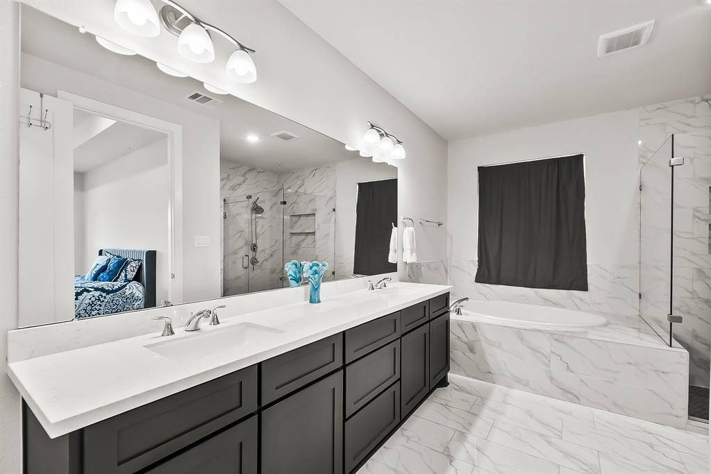 Sleek primary bathroom with dual vanities.