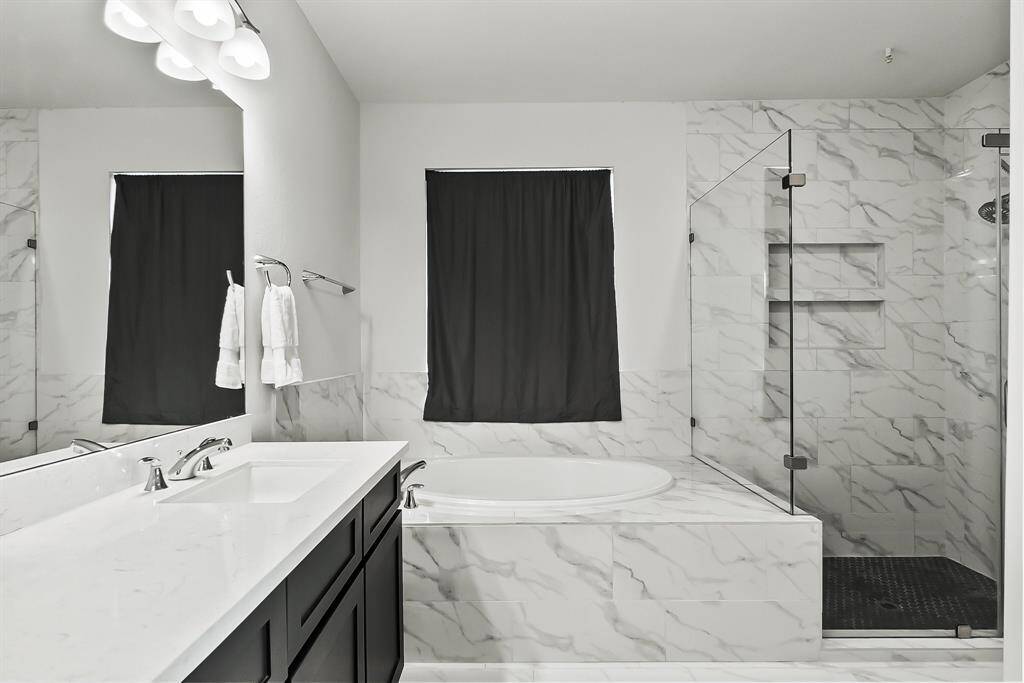 Oversized shower with frameless glass enclosure.